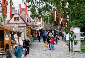 Entlang der Straße &quot;An der Burgkirche&quot; stehen Verkaufsstände für den kulinarischen Genuß. Hier ist für jeden Geschmack was dabei. Wenn man die Straße weitergeht, kommt man durch den Torbogen, an den Bereich vor der Turnhalle Ober-Ingelheim. © Michael Bellaire/IKuM GmbH